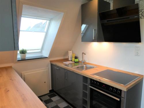a small kitchen with a sink and a stove at Sommerwind in Eutin