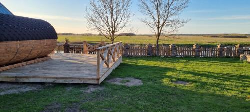 a wooden deck in a yard with a fence at Filipówka in Sztabin