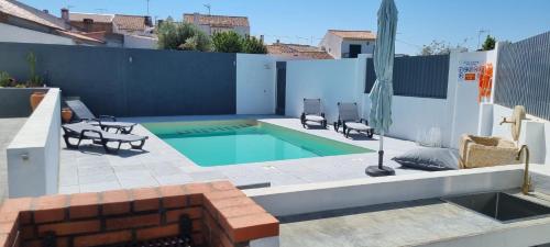 a backyard with a swimming pool and two chairs at Russa AL in Lentiscais