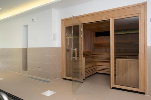 a large wooden closet with glass doors in a room at 8 Putsborough - Luxury Apartment at Byron Woolacombe, only 4 minute walk to Woolacombe Beach! in Woolacombe