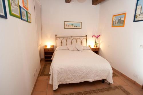 1 dormitorio con 1 cama con sábanas blancas y 2 mesas en B&B Del Prato, en Bagnoregio