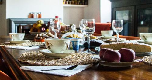 a wooden table topped with dishes and wine glasses at B&B Del Prato in Bagnoregio