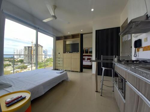 a hotel room with a bed and a large window at Terrazas Tayrona Travelers Apartamentos y Suites in Santa Marta