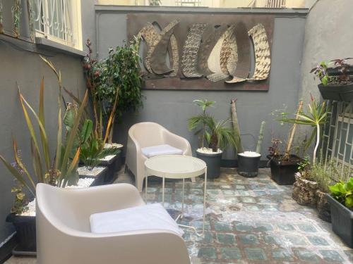 a patio with a table and chairs and plants at Bel Appart Cosy plein coeur de Tanger vue mer in Tangier
