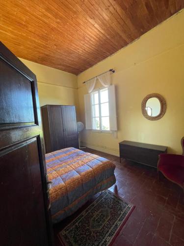 a bedroom with a bed and a window at Villa di Corliano Relais all'Ussero in San Giuliano Terme