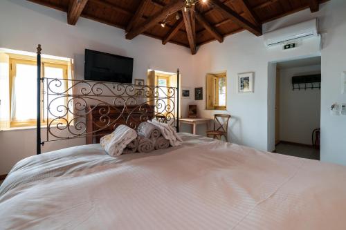 a bedroom with a large white bed with a television at Rafalias Mansion in Hydra