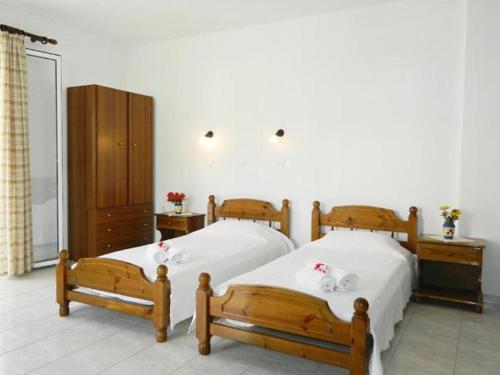 - une chambre avec 2 lits jumeaux et une armoire dans l'établissement ARISTON APARTMENTS, à Poros