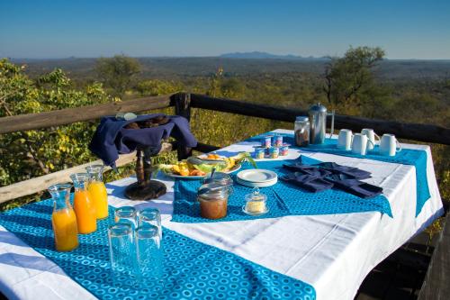 a blue and white table with food and drinks on it at Ezulwini Game Lodges in Balule Game Reserve