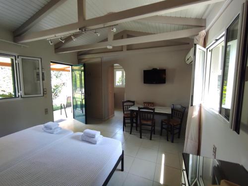 une chambre avec deux lits et une salle à manger avec une table dans l'établissement Volta Villas Lefkada, à Leucade