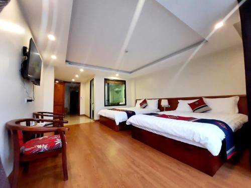 a hotel room with two beds and a flat screen tv at Sapa Star Hotel in Sapa