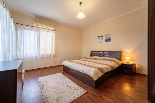 a bedroom with a bed and a desk and a window at Къщата с Кладенеца - с. Генерал Кантарджиево in General-Kantardzhievo