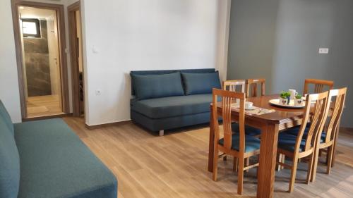 a living room with a table and a blue couch at Soula Apartments & Studios in Palaiochora