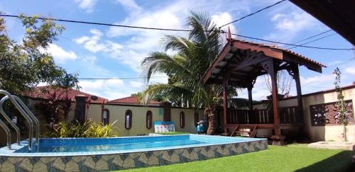 a house with a swimming pool and a gazebo at Achutra Muslim Guesthouse (pool) in Melaka