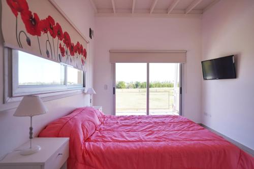 1 dormitorio con 1 cama con colcha roja y ventana en Antares en 