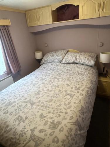 a bedroom with a bed with a white bedspread at Private Holiday home in calm site in Wootton Bridge