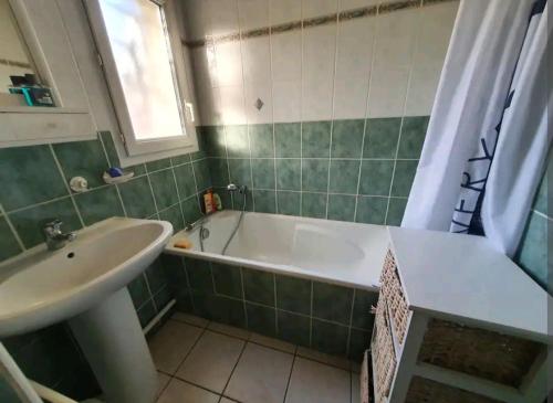 La salle de bains est pourvue d'une baignoire et d'un lavabo. dans l'établissement Maison idéalement située pour 6 personnes, à Soustons