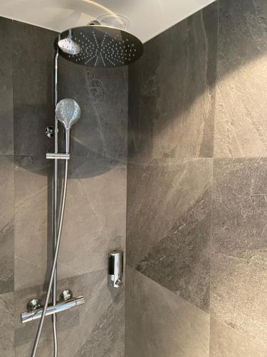 a shower with a shower head in a bathroom at LE CLOS DES SOURCES Hôtel & Spa in Thannenkirch