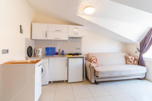 eine kleine Küche mit einem Sofa und einem Tisch in der Unterkunft Apartments Near to City Center and Beach in Marmaris