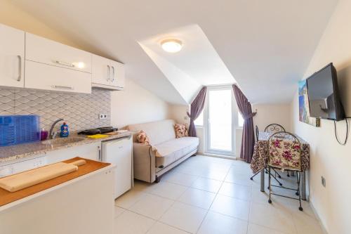 eine Küche und ein Wohnzimmer mit einem Sofa in der Unterkunft Apartments Near to City Center and Beach in Marmaris