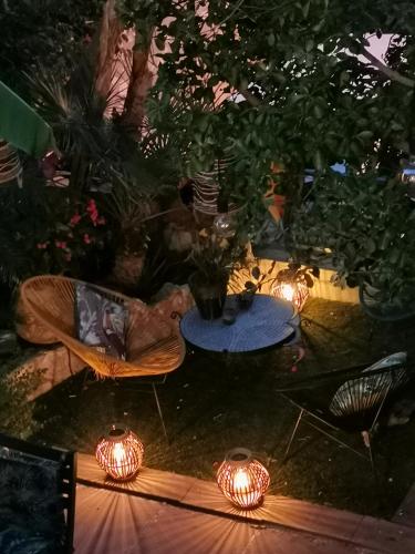 une arrière-cour avec des lumières, une table et des chaises dans l'établissement And&Col Jardin ,terrasse & climatisation, à Marseille