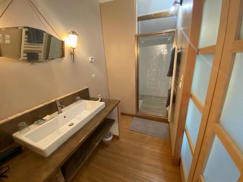 a bathroom with a white sink and a window at Entre Tarn et Causses in Le Recoux
