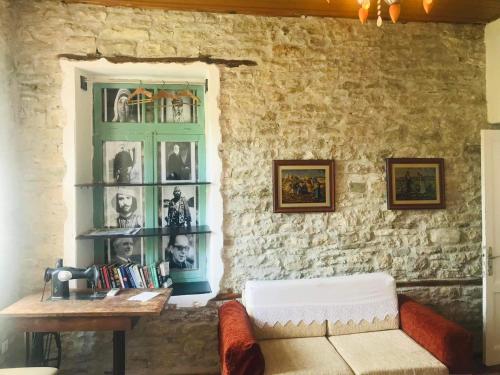 a living room with a couch and a stone wall at Flora's Guesthouse 'The Fir Gate' in Gjirokastër