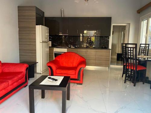 sala de estar con muebles de color rojo y cocina en luxury apartment 11' from Athens center, en Atenas