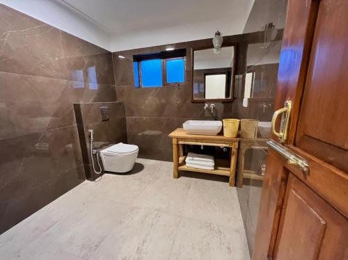 a bathroom with a toilet and a sink at Hotel Kang Lha Chen in Leh