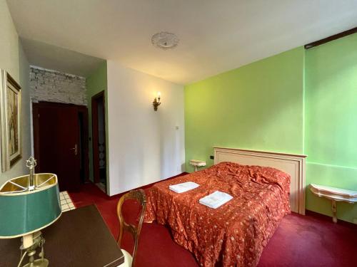 a bedroom with a bed with green walls and a table at Ai Boteri in Venice