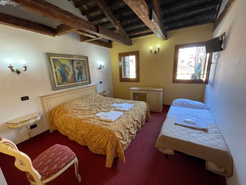 - une chambre avec un lit et deux chaises dans l'établissement Ai Boteri, à Venise