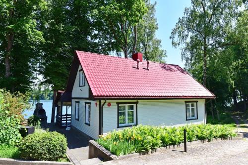 a small house with a red roof in a garden at Slėnis Trakuose in Trakai