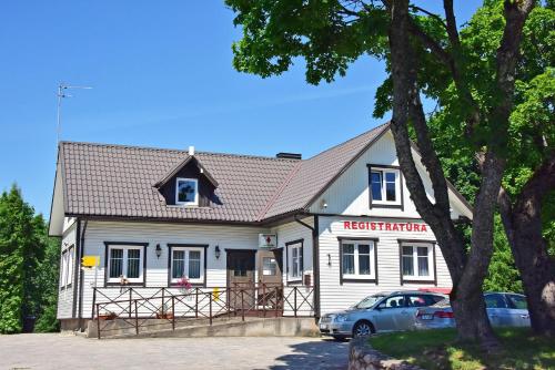 a white house with a car parked in front of it at Slėnis Trakuose in Trakai