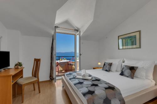 1 dormitorio con cama, escritorio y ventana en Apartments Danica Drašnice, en Drasnice