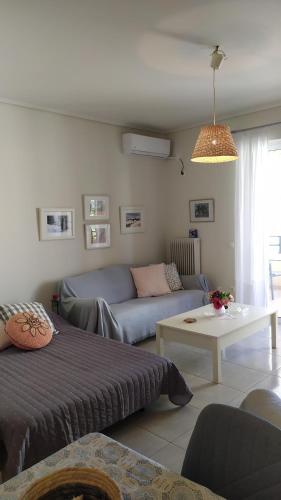 een woonkamer met een bank en een woonkamer met bij Marilena's Apartment in Rafina