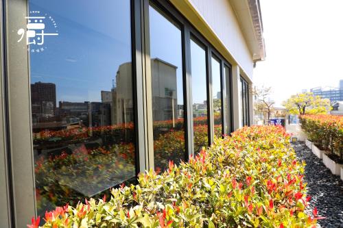 a building with a display of flowers in a window at Roots Chew Hotel in Tainan