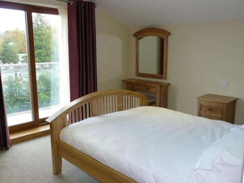 a bedroom with a bed and a large window at Cherry Lodge in Penrith