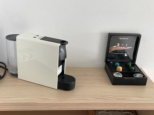 a black and white coffee maker on a wooden shelf at Thalassa view in Áyioi Apóstoloi