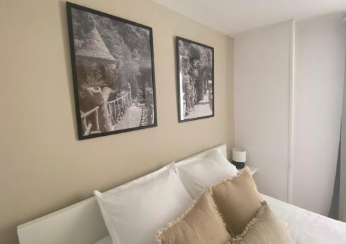 1 dormitorio con 2 fotos colgando sobre una cama en Apartamento con encanto en el Pirineo, en La Pobla de Lillet