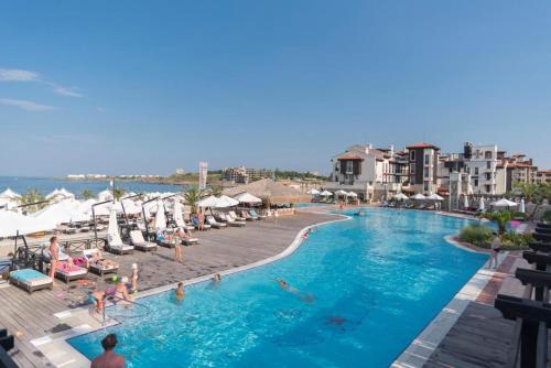 uma piscina num resort com pessoas a nadar nela em Oasis Resort & Spa Cozy Studio em Lozenets