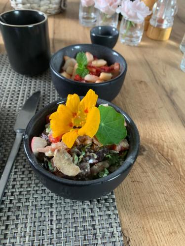 two bowls of food sitting on a wooden table at B&B L'Echappée Belle Welness Spa et Table d'hôtes in Falaën