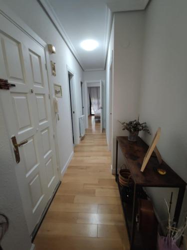 a hallway with a white door and a wooden floor at Sagasti in Astigarraga
