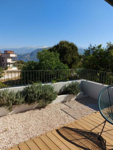 a wooden deck with a bench and some plants at Hermes&Dione in Argoulidhés