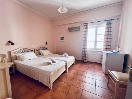 um quarto com 2 camas e uma janela em A Hotel em Spetses