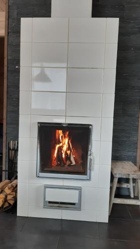 a white fireplace with a fire in it at Skicamp 3 in Pyhätunturi