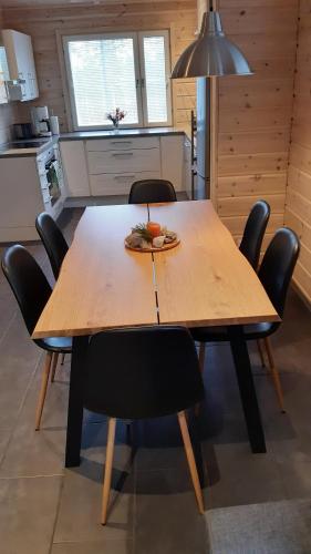 Skicamp 3 في Pyhätunturi: طاولة وكراسي خشبية في مطبخ