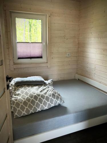 a small room with a bed and a window at DOMKI SILVER 2 in Jarosławiec