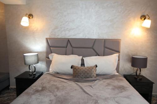 a bedroom with a large bed with two nightstands and two lamps at Equi Palace & SPA Near Aeroport in Berrechid
