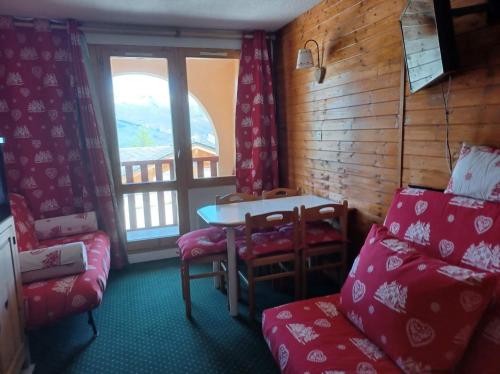 une pièce avec une table, des chaises et une fenêtre dans l'établissement appart entierement renové les coches - la Plagne, à Bellentre