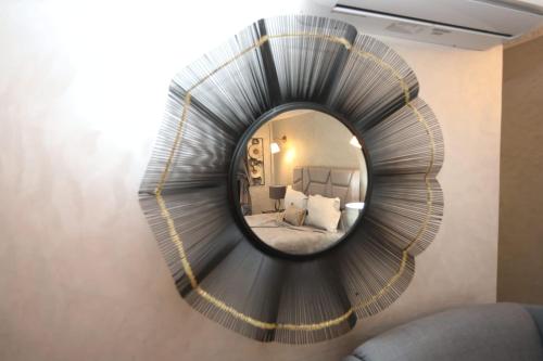 a mirror hanging on a wall in a bedroom at Equi Palace & SPA Near Aeroport in Berrechid