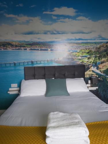 a bedroom with a bed with a view of the water at No 27 Chapel Street Guest House in Llandudno